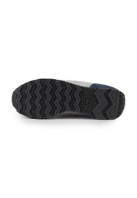 Suela de goma negra con patrón de tracción en zigzag y logo en relieve. Presenta un upper de ante gris y marino y diseño de punta redondeada. Tacón plano.