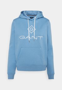 Sweat à capuche bleu clair avec poche kangourou, cordons de serrage et logo blanc. Tissu doux, poignets et ourlet côtelés pour un ajustement confortable.