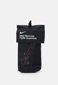 Borsa Nike Mercurial Flylite Superlock; tessuto nero con chiusura arrotolata, logo bianco, accenti rossi e finitura testurizzata con fori di ventilazione.