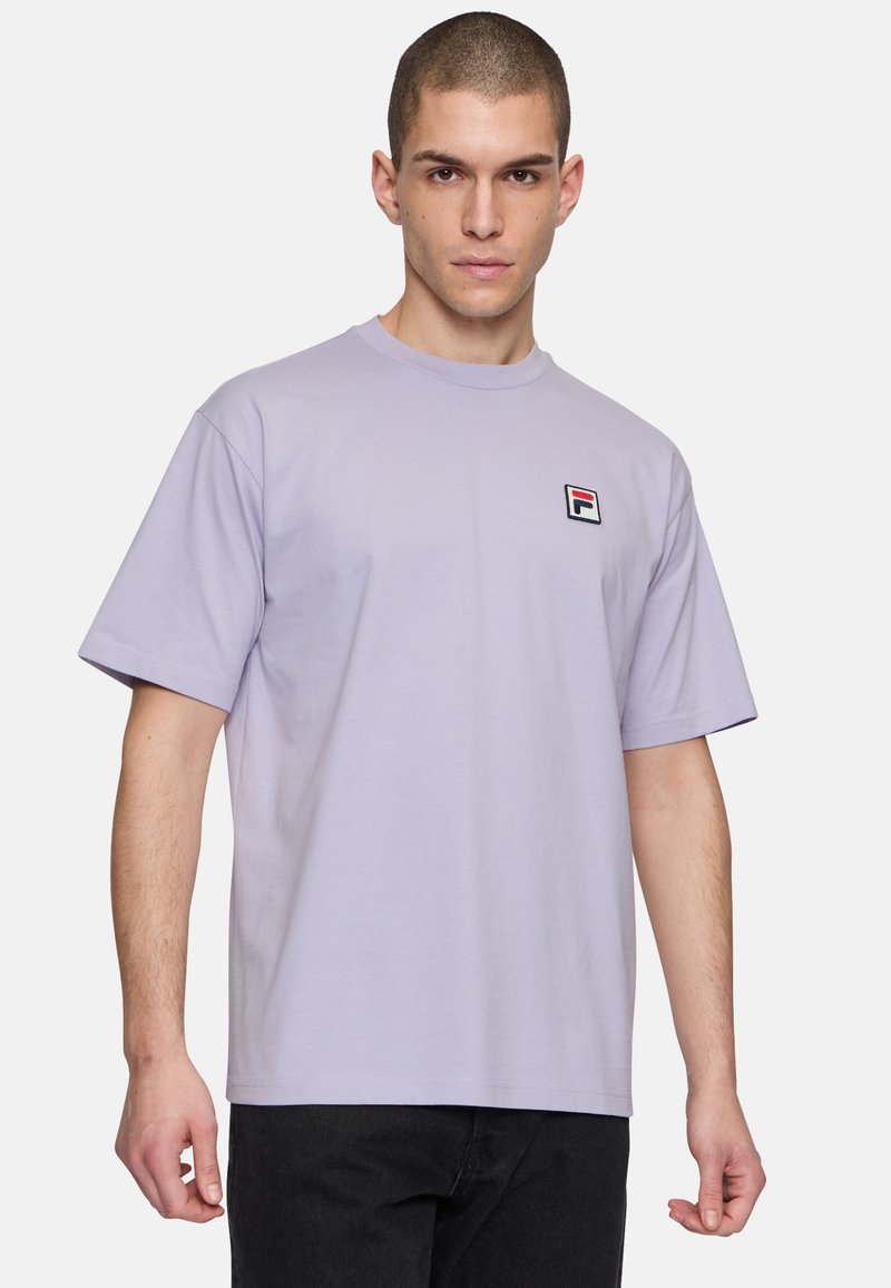 Camiseta de algodón de color púrpura claro con mangas cortas y cuello redondo. Presenta un pequeño logo bordado en el pecho. Corte estándar.