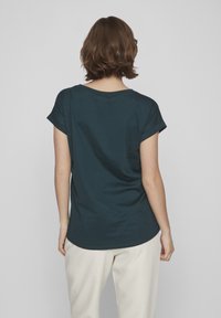 Dark teal short-sleeve t-shirt with a relaxed fit and rolled sleeves, featuring a round neckline and soft, smooth texture.