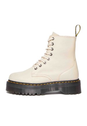 Stivali alla caviglia bianchi in pelle con suole in gomma nera, caratterizzati da cuciture gialle e design con lacci, una linguetta sul retro per facilitare la calzata.