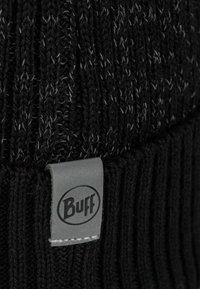Black knitted beanie with a ribbed texture, featuring subtle gray speckles and a gray fabric label with the "Buff" logo stitched on.