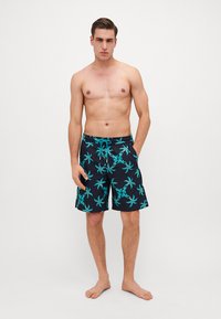 Fekete fürdőshorts türkiz pálmamagas mintával, elasztikus derékpánttal és zsinórral. Oldalzsebekkel és combközép hosszúsággal rendelkezik.