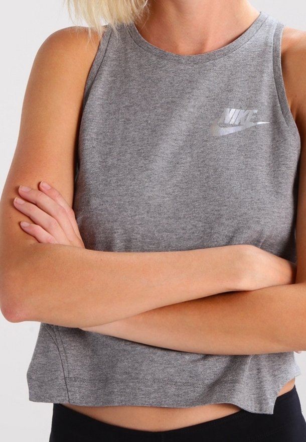 Grå ärmlös crop top i bomullsblandning, med en liten reflexiv Nike-logotyp på bröstet, rund halsringning och avslappnad passform.