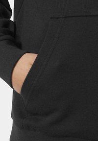 Sudadera negra con bolsillo frontal. La textura es suave, con un dobladillo y puños acanalados, que muestra un acabado de tejido liso y uniforme.