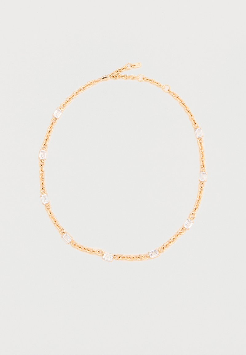 Κολιέ με χρυσή αλυσίδα και ορθογώνιους διάφανους πολύτιμους λίθους τοποθετημένους ομοιόμορφα σε μια ελαφριά ουδέτερη φόντο, με το κούμπωμα ορατό στο επάνω μέρος.