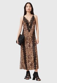 Abito a sottoveste con stampa leopardata, caratterizzato da accenti in pizzo nero, una profonda scollatura a V e una silhouette fluida. Abbinato a una pochette nera testurizzata e tacchi con frange.