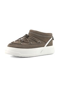 Zapato marrón de ante tipo slip-on con suela blanca gruesa, parte delantera de cordones elásticos y franja reflectante en el lateral.