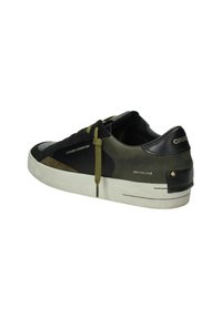 Sneaker nere e verde oliva con un upper in suede e pelle testurizzato, una suola in gomma bianca e lacci verdi. Logo impresso sul tallone.