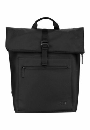 Sac à dos noir à rabat, avec poche zippée à l'avant, poignée supérieure et fermeture à sangle boucle, marqué "Jost" en bas à droite.