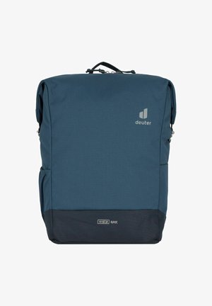 Rucksack aus dunkelblauem Stoff mit umklappbarem Deckel, grauem Logo und kontrastierendem schwarzen Boden. Verfügt über eine Seitentasche und eine strukturierte Oberfläche.