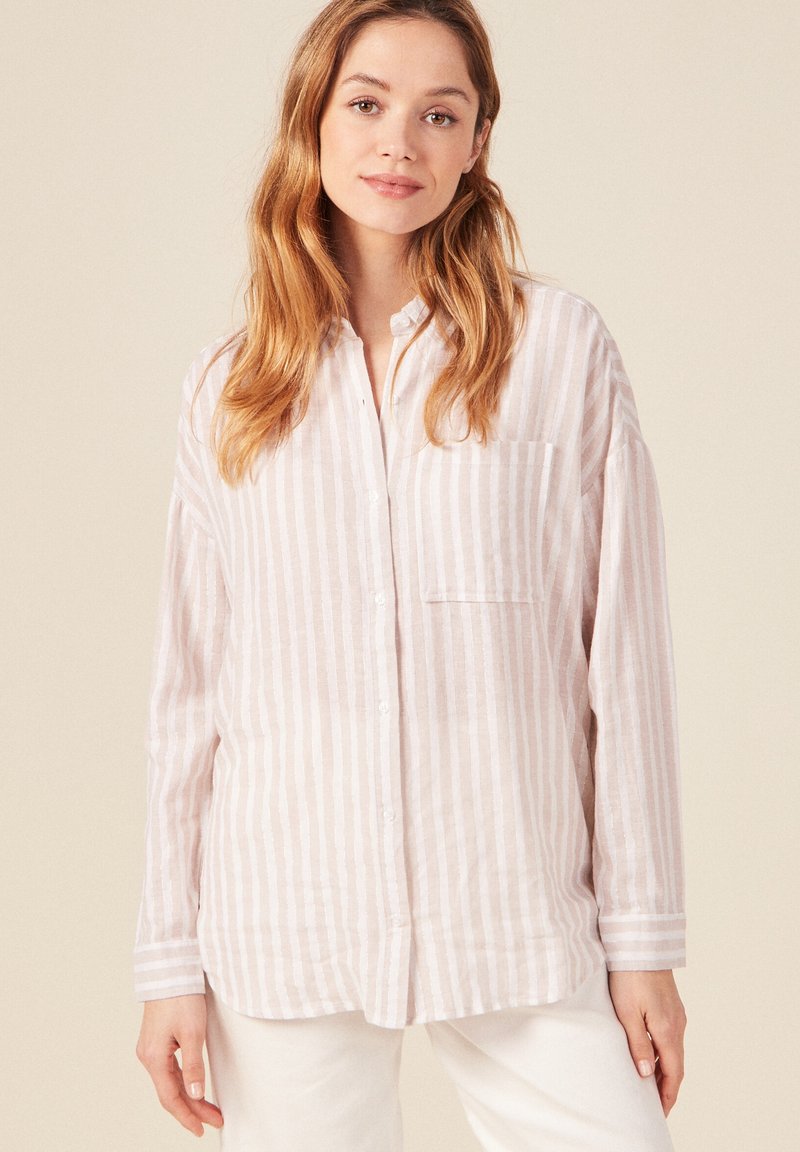 Camicia a righe rosa chiaro e bianco, maniche lunghe, con bottoni sul davanti, tasca sul petto, realizzata in tessuto morbido, vestibilità rilassata.