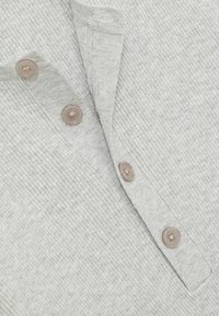 Cămașă din material ribbed de culoare gri deschis, cu un placket cu nasturi și două nasturi de culoare maro deschis, și un guler pliat. Textura este moale și țesută.