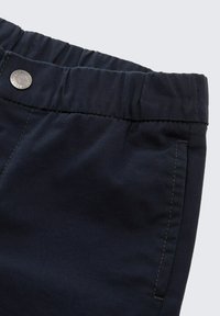 Marineblauwe stoffen broek met een elastische tailleband, voorzien van een voorste knoop, gestikte details en een gladde textuur.