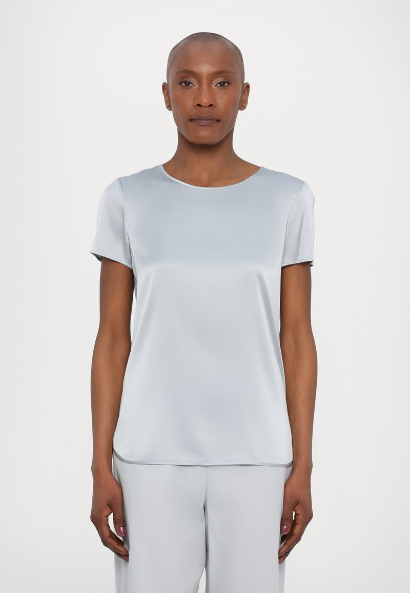 Top curto de manga curta em azul claro, feito de um tecido suave e semelhante a cetim, com um decote redondo e um corte descontraído. Realça linhas limpas sem padrões.