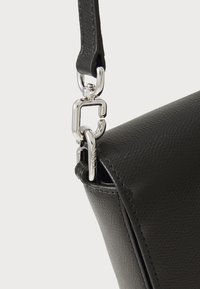 Borsa a tracolla nera in pelle con finitura testurizzata, dotata di un attacco in metallo argentato e di una lunga tracolla.