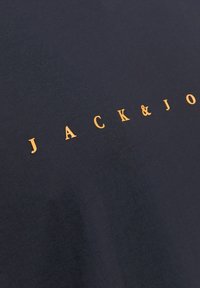 Navyblauwe katoenen T-shirt met een opvallend oranje "JACK&JO" logo op de borst, met een gladde, effen textuur.