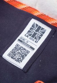 Label met zwarte tekst op een witte achtergrond toont het merk "J&JOY," een QR-code en onderhoudsinstructies. Paarse stof met oranje accentdetails.