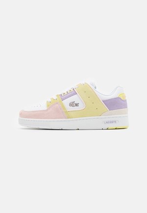 Sneakers basses avec base blanche, panneaux en daim rose pastel, jaune et lavande, logo Lacoste sur le côté et semelle en caoutchouc blanche.