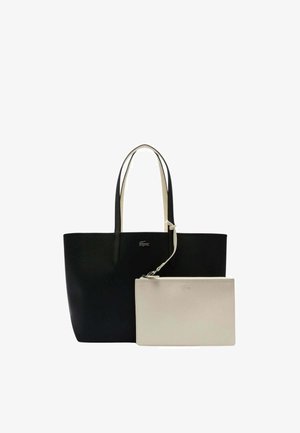 Bolso tote negro con asas color crema, que presenta un logo de Lacoste. Incluye una bolsa con cremallera en un tono gris claro, extraíble, con un logo a juego.
