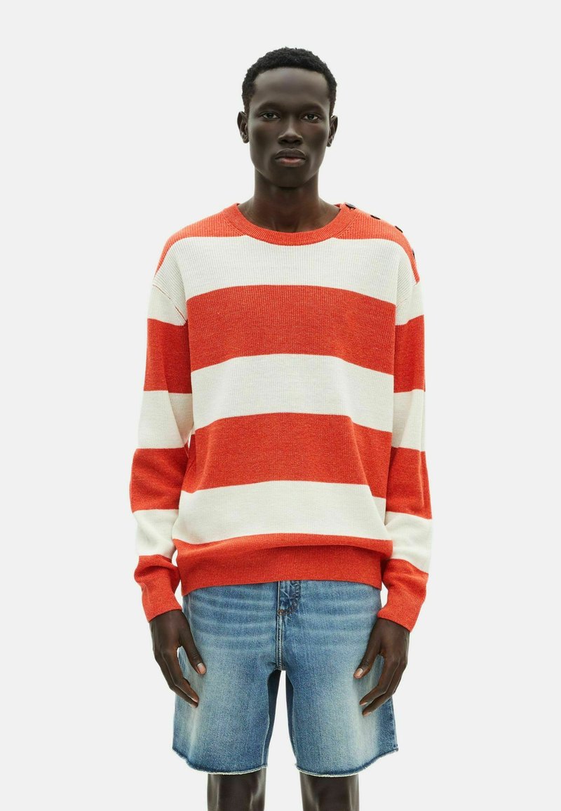Gestreifter roter und weißer Strickpullover mit Rundhalsausschnitt und gerippten Säumen, kombiniert mit hellblauen Jeans-Shorts.
