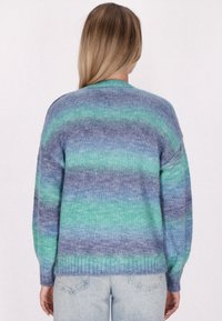 Maglione lavorato a maglia con una combinazione di strisce blu e verdi, con orlo e maniche a costine. Texture morbida con una vestibilità comoda.