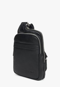 Černá kožená crossbody taška s texturovaným povrchem, několika zipovými oddíly a elegantním designem. Obsahuje nastavitelný popruh a detail loga.