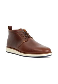 Brown leather ankle boots with contrasting white and navy sole, round toe, and minimalistic design, featuring a lace-up closure and back tab.