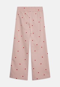 Minkštų rožinių audinių kelnės su laisvu siluetu, turinčios raukinėtą juosmenį ir išsibarsčiusias raudonų širdžių raštų visur.