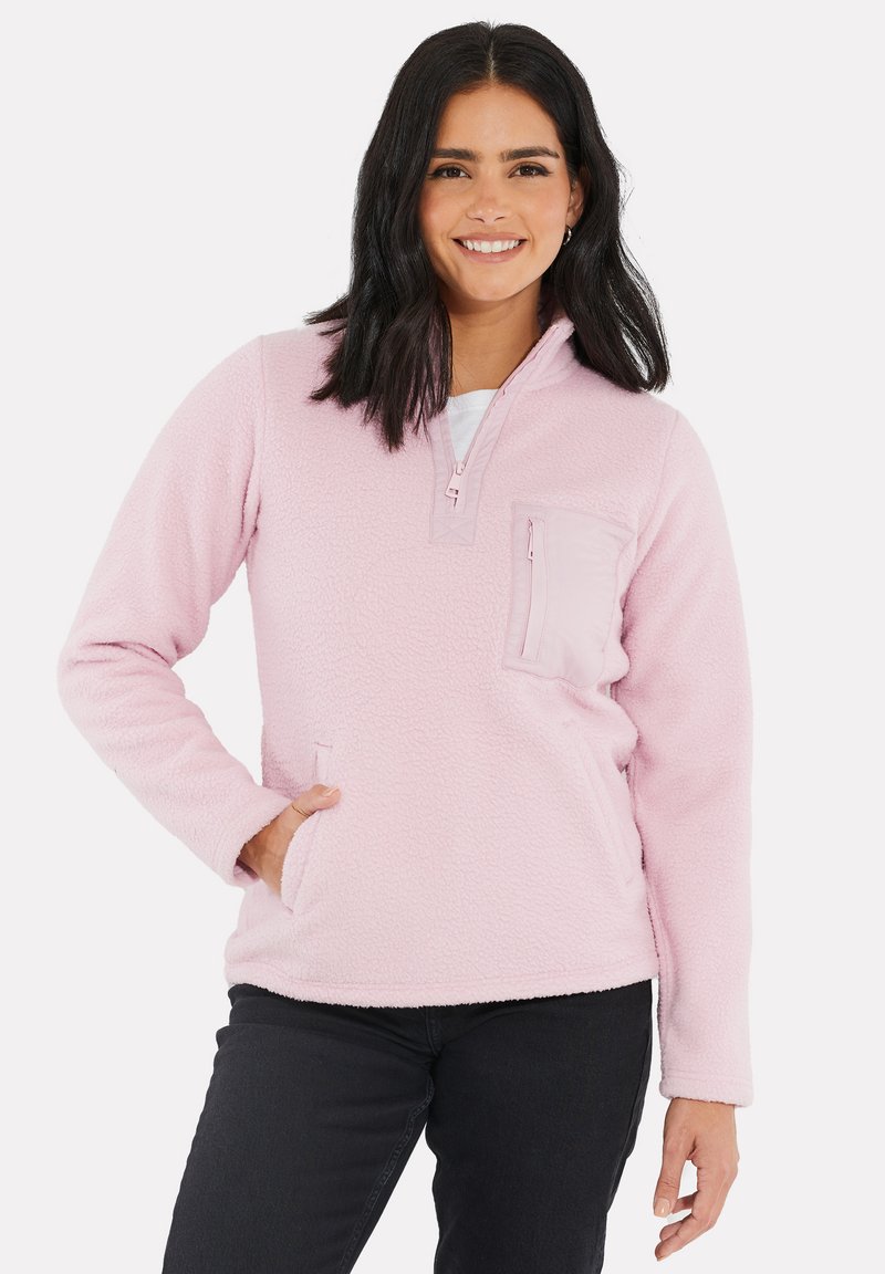 Pullover en polaire rose clair avec un demi-zip, une poche frontale et des manches longues. Le tissu semble doux avec une finition texturée.