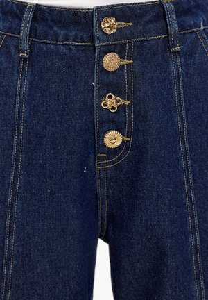 Pantalon en denim taille haute bleu foncé, avec quatre boutons dorés ornés, des accents cousus et une coupe structurée avec poches arrière.