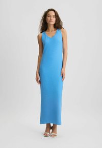 Sinine, varrukavaba maksikleit V-kaeluse ja tekstureeritud pinnaga, sirge lõikega. Kanda valgete slip-on sussidega.