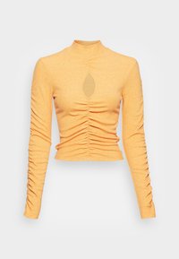 Top cropped de manga longa em tecido canelado laranja claro. Apresenta uma leve franzido, gola alta e um recorte em forma de olho-chave na frente.