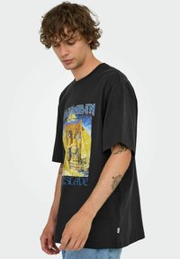 Sort grafisk t-shirt lavet af bomuld, med et farverigt design af en pyramide og sphinx. Løs pasform med korte ærmer og rund hals.