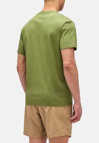 T-shirt in cotone verde oliva con scollatura a girocollo, maniche corte e vestibilità rilassata, vista dal retro. Texture liscia e design semplice.