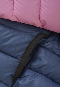 Różowo-granatowa kurtka puchowa z pikowanym wzorem; posiada czarną elastyczną taśmę blisko krawędzi, ukazując gładkie, błyszczące materiały.