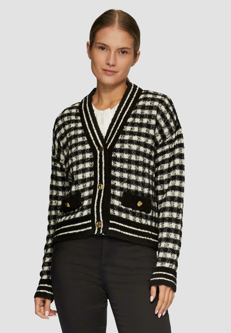 Schwarz-weißer karierter Cardigan mit V-Ausschnitt, goldenen Knöpfen, strukturierten Taschen und gestreiftem Detail entlang des Saums und der Ärmel.
