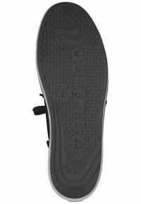 Černá gumová podrážka boty s texturovaným, vzorovaným gripem, obsahující vyvýšené kruhové tečky a vybílený text. Rovný profil s zaoblenými hranami.