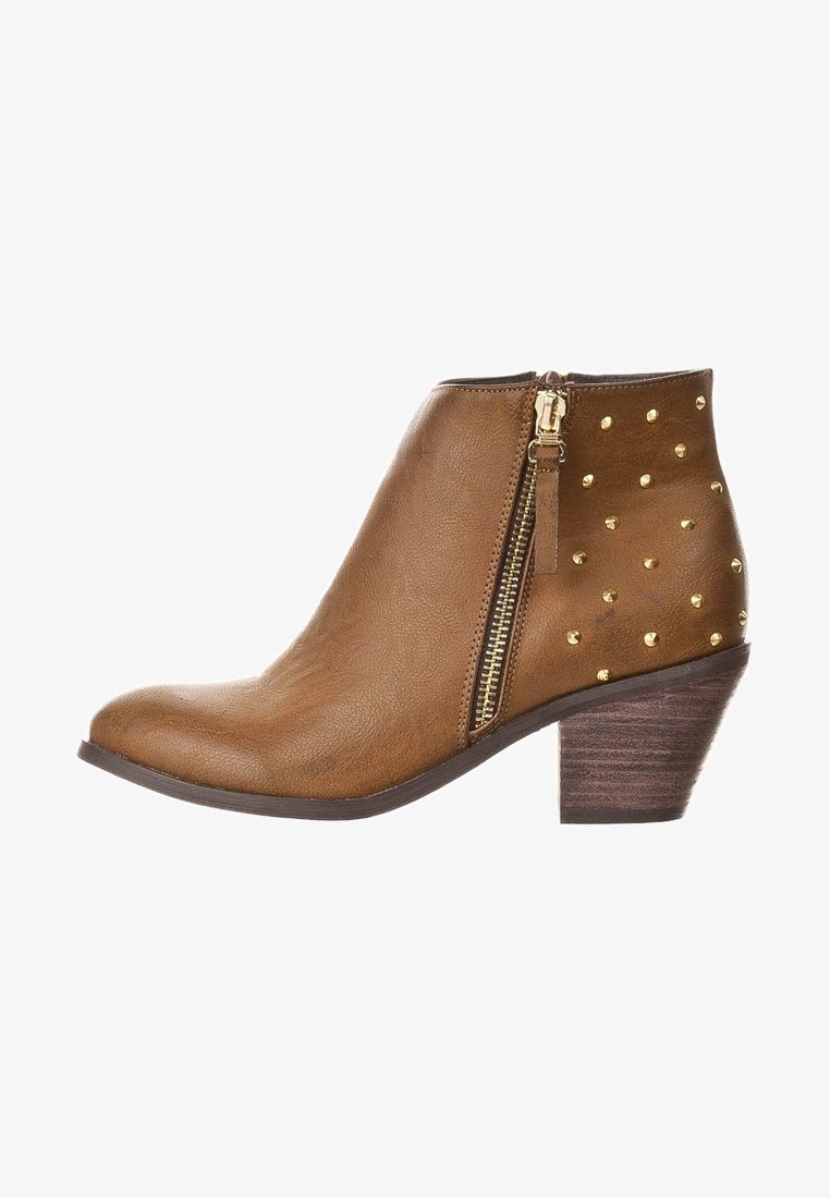 Stivale alla caviglia color tan realizzato in faux leather texturizzato, con una cerniera laterale e borchie dorate su un lato, dotato di un tacco in legno impilato.