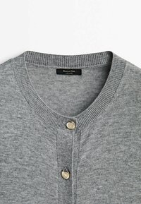 Cardigan en maille gris clair avec encolure ronde côtelée et deux boutons métalliques décoratifs au centre devant.