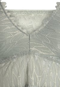 Light green dress with a scalloped neckline. Features intricate leaf patterns and a textured fabric with a subtle sheen.