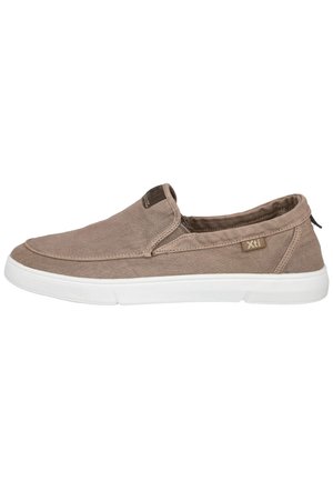 Zapatilla deportiva informal tipo slip-on con parte superior de tela marrón clara, suela de goma blanca y etiqueta de la marca Xti en el lateral y la lengüeta.