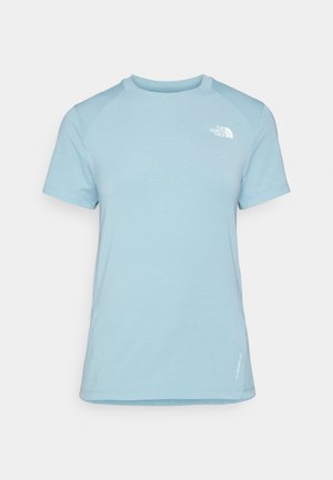 Svetlo modré tričko s krátkym rukávom a okrúhlym výstrihom. Má mäkkú tkaninu, raglánové rukávy a biele logo v hornej ľavej časti hrudníka.