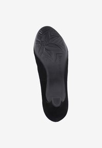 Semelle de chaussure noire avec surface en caoutchouc texturée, présentant un motif floral et un nom de marque embossé. Taille 38 indiquée sur la semelle.
