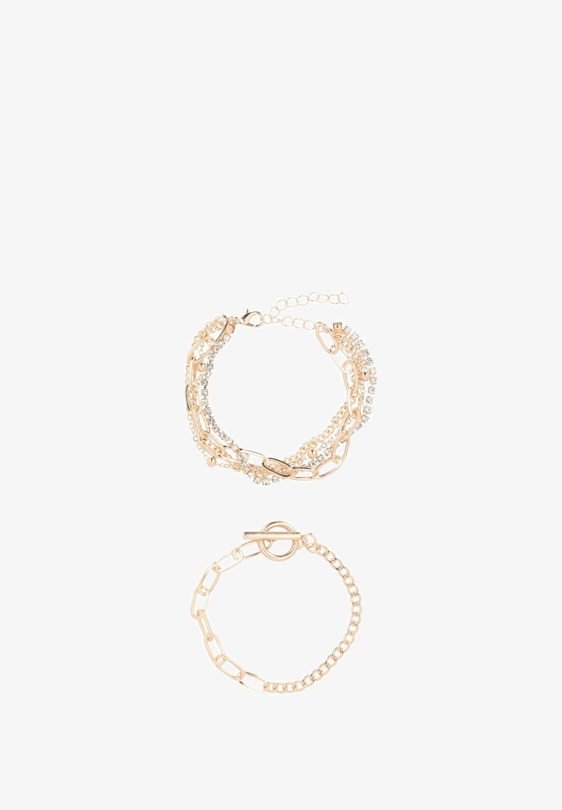 Kulta-toned rannekorusetti, jossa on kerrostettu muotoilu ketjunkuulilla ja kirkkailla rhinestoneilla. Mukana alarannekorun kiinnitys.