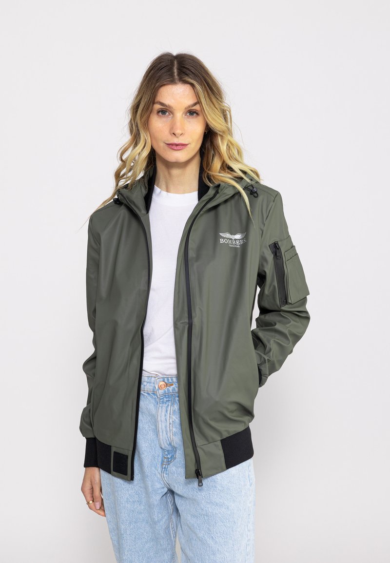 Olive green bomber jacket with a smooth, water-resistant material, featuring a zip front, elastic cuffs, and a logo on the chest.