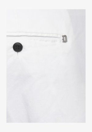 Tessuto bianco con un bottone nero a quattro fori e una piccola cerniera metallica vicino a una cucitura orizzontale o al bordo di una tasca.