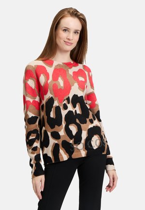 Knit sweater featuring a leopard print design in red, black, and brown on a beige background, with a rounded neckline and decorative accents.