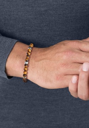 Perlenarmband mit braunen und goldenen Tigeraugensteinen und silbernen Abstandshalterperlen, vor einem strukturierten grauen Pullover-Hintergrund.
